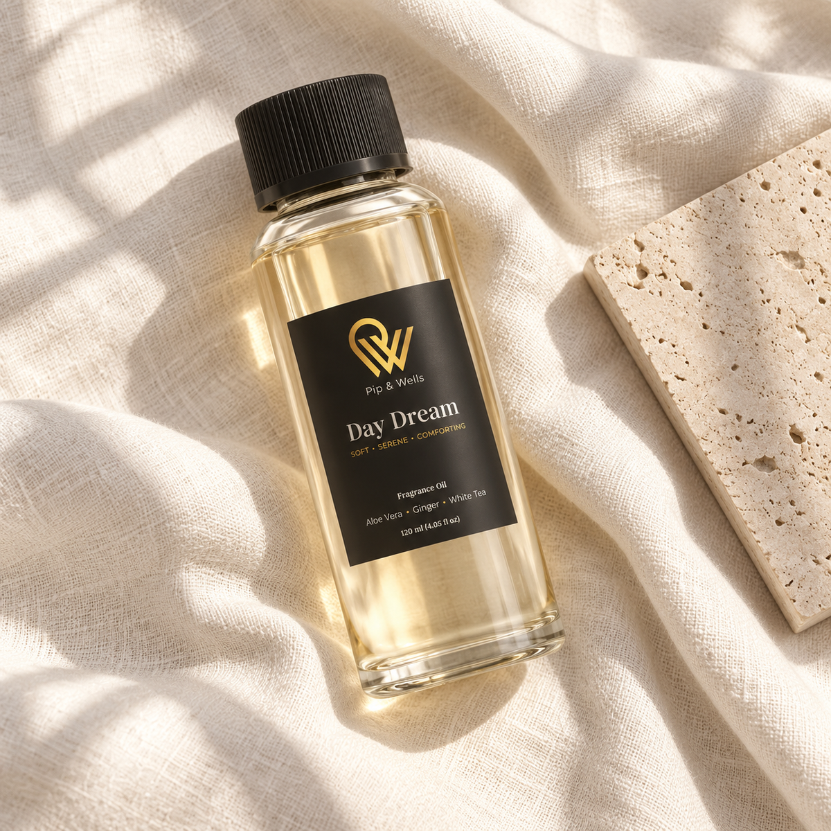 Butelka olejku zapachowego Pip & Wells Day Dream o pojemności 120 ml na jasnym lnie obok płytki kamiennej z fakturą
